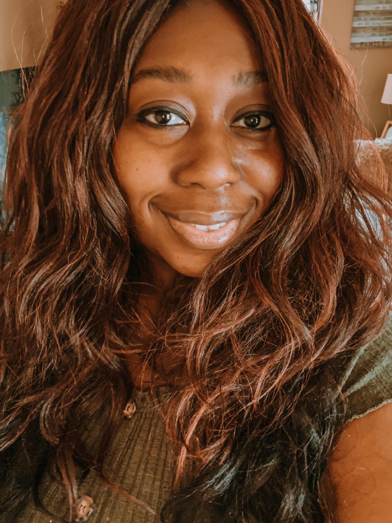 Black woman, Tiffany Hammond, with long, reddish-brown hair smiling into the camera