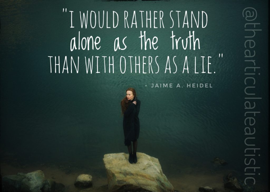 An image of a woman with red hair standing on a rock by the sea with text that reads, "I would rather stand alone as the truth than with others as a lie." - Jaime A. Heidel