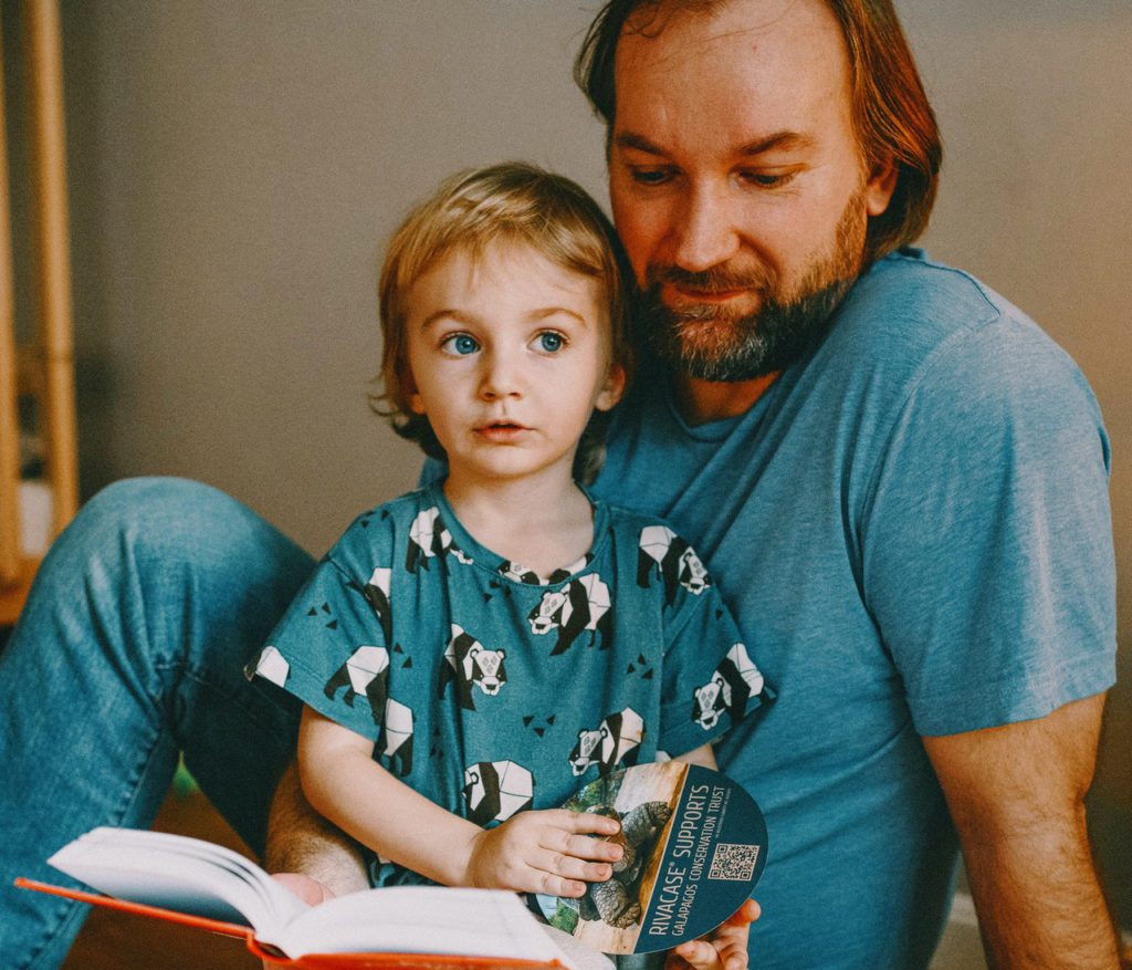 Father and child sitting together quietly. They are wearing all blue.