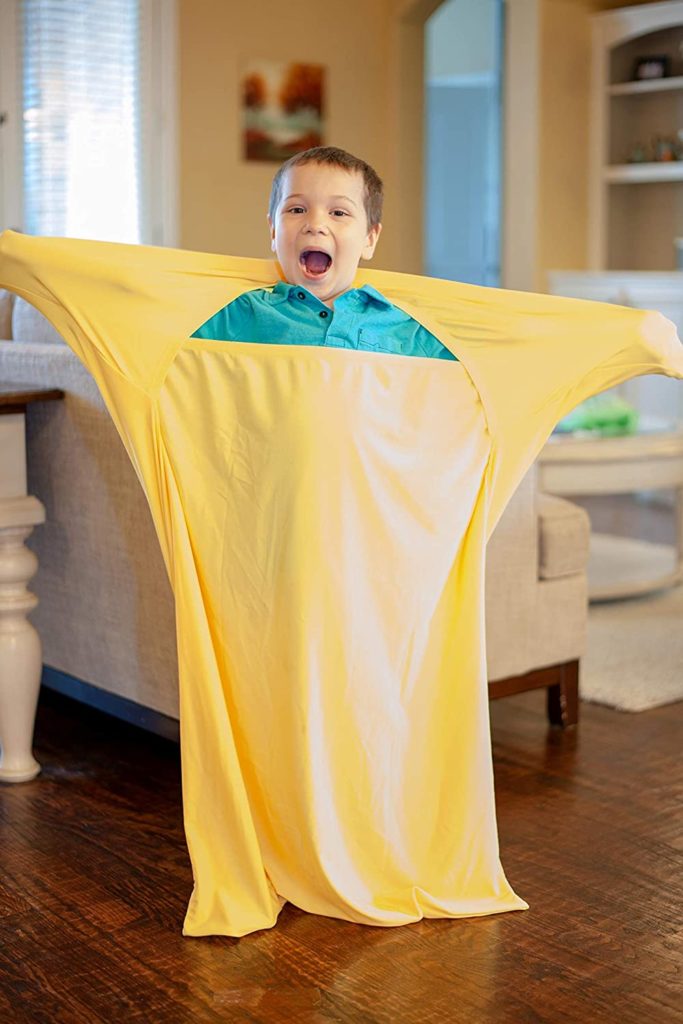 Cute little boy using a yellow sensory sock and looking very happy.