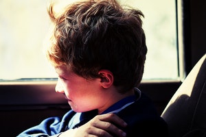 Young child looking out of a vehicle window.