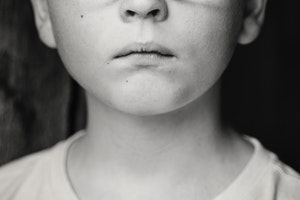 Black and white photo of a boy's face from the nose down.