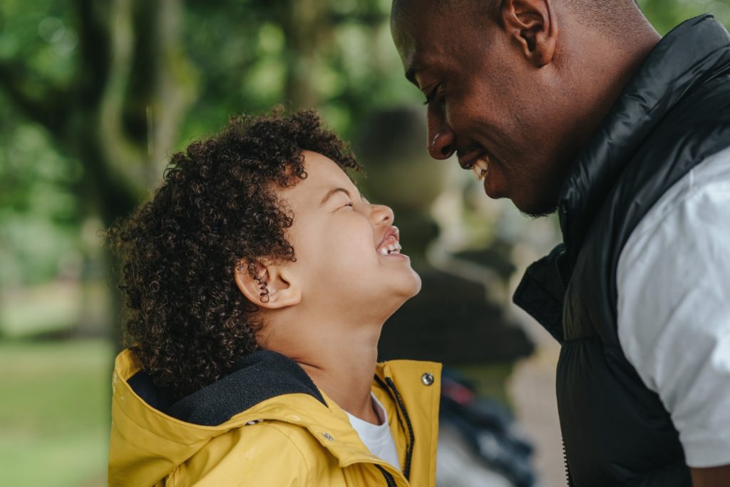 Father and son smiling at each other. 