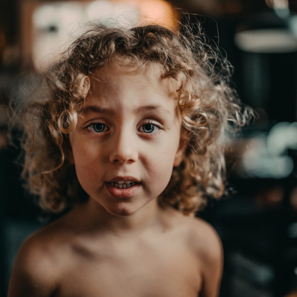Child with blonde, curly hair and blue eyes.