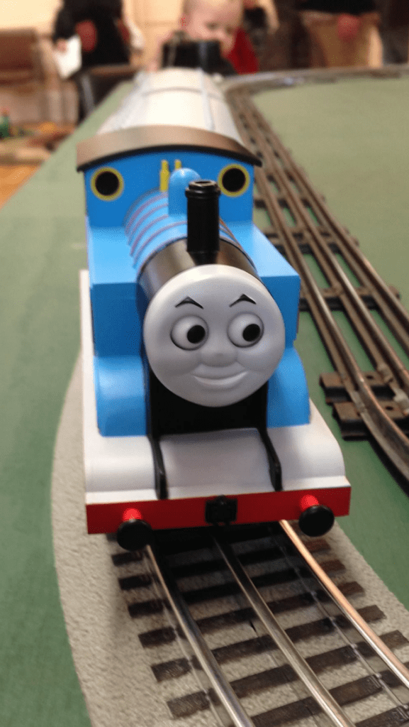 A closeup photo of Thomas the Tank Engine on a train track. 